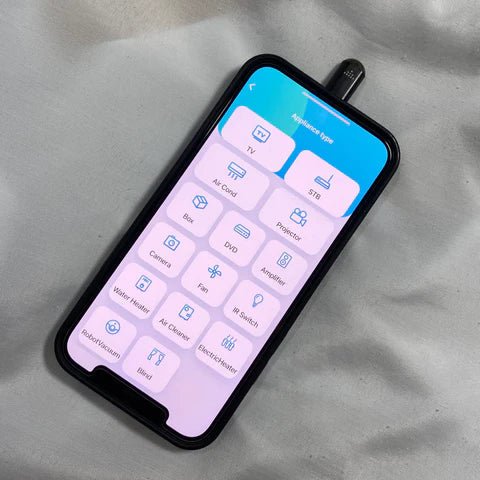 Infrared smartphone adapter plugged into phone controlling multiple home electronics via app